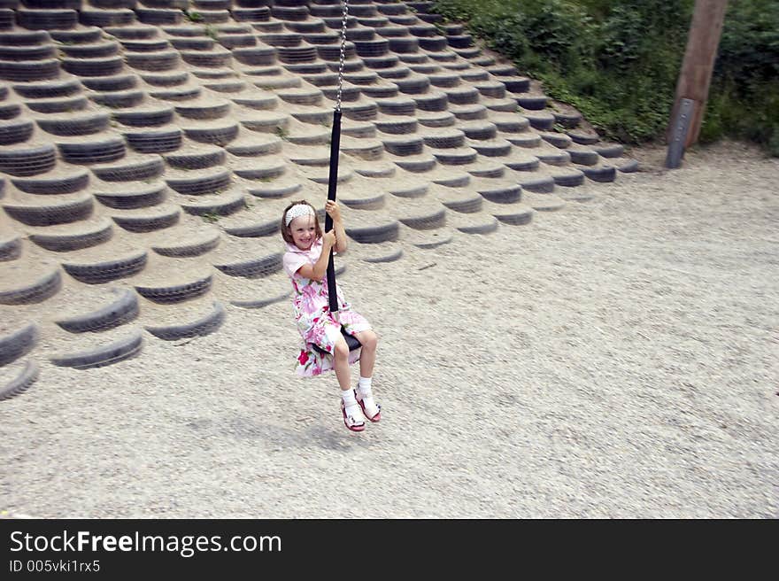 Young girl swinging on a playground. Young girl swinging on a playground