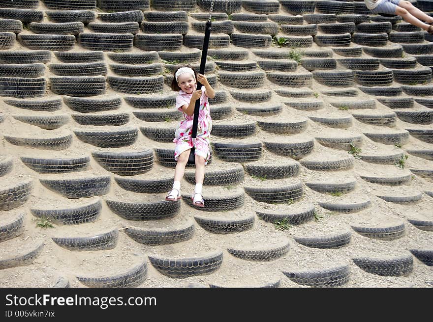 Young girl swinging on a playground. Young girl swinging on a playground