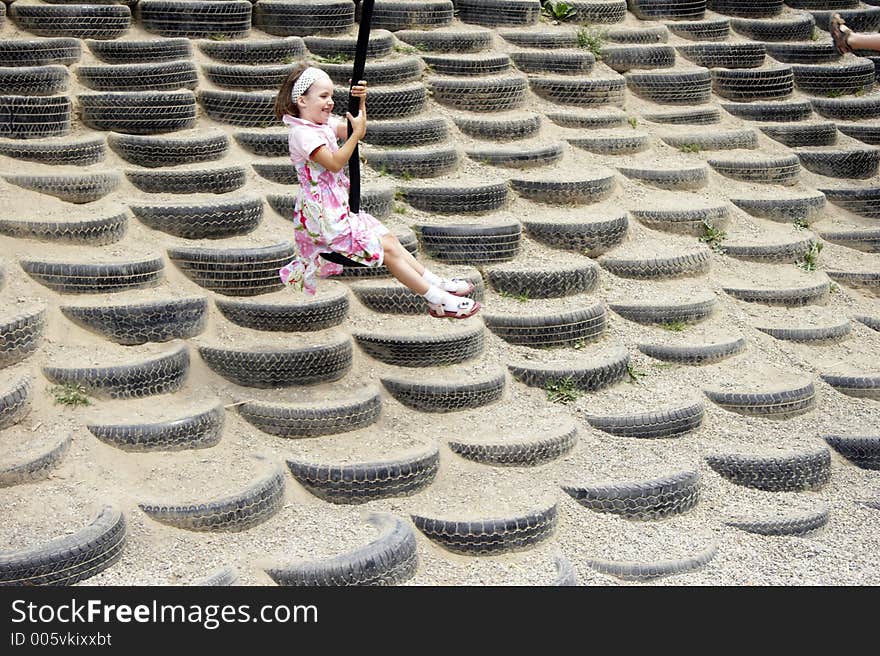 Young girl swinging on a playground. Young girl swinging on a playground