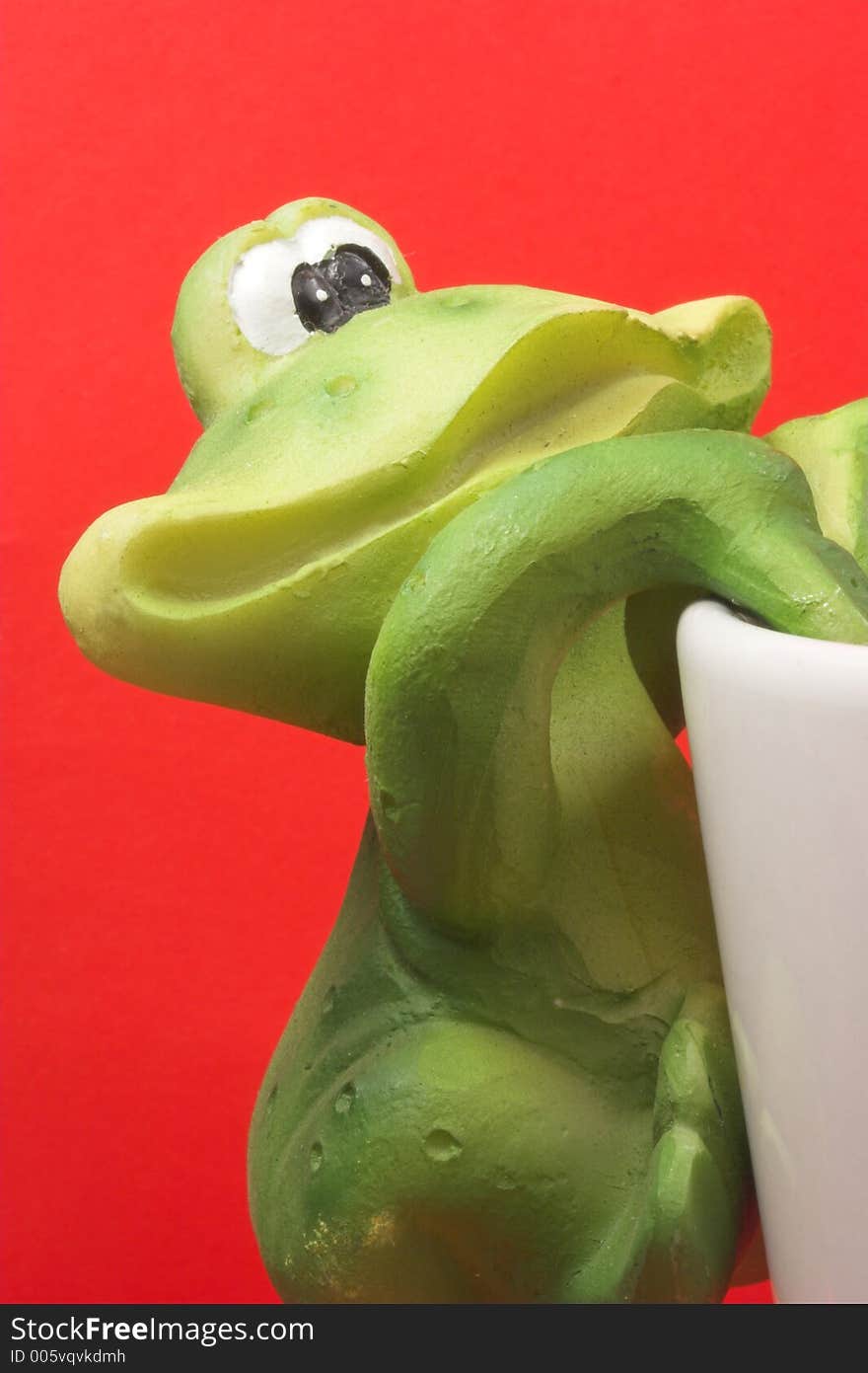 Frog climbing coffee cup. Frog climbing coffee cup