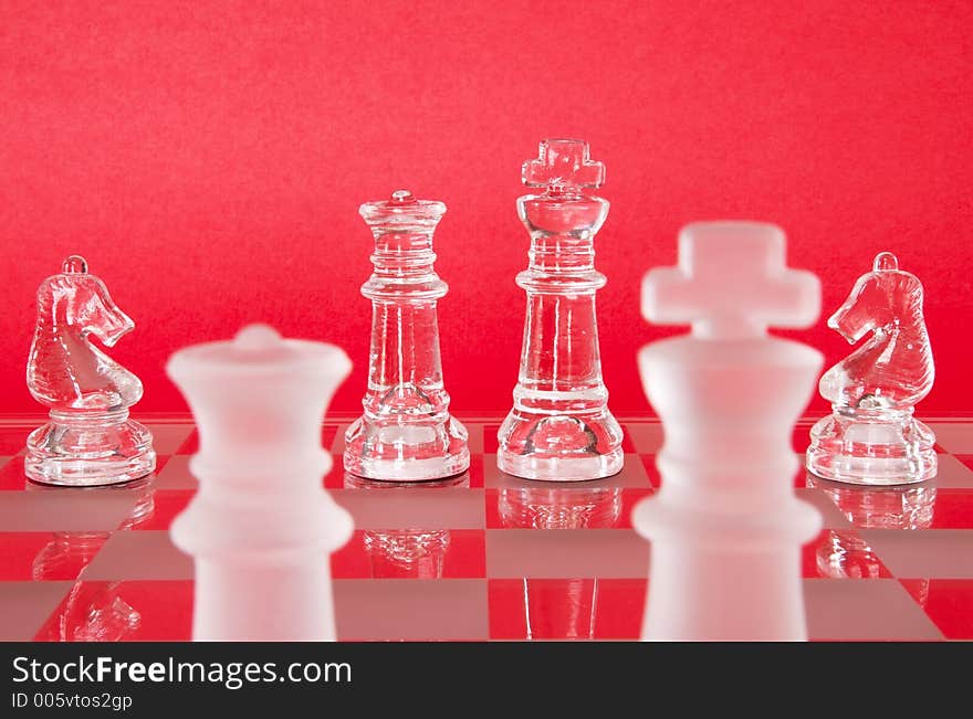 Chess game in glass. The Queen, King and Knights as seen from the view of the Opposing Queen and King. Chess game in glass. The Queen, King and Knights as seen from the view of the Opposing Queen and King.