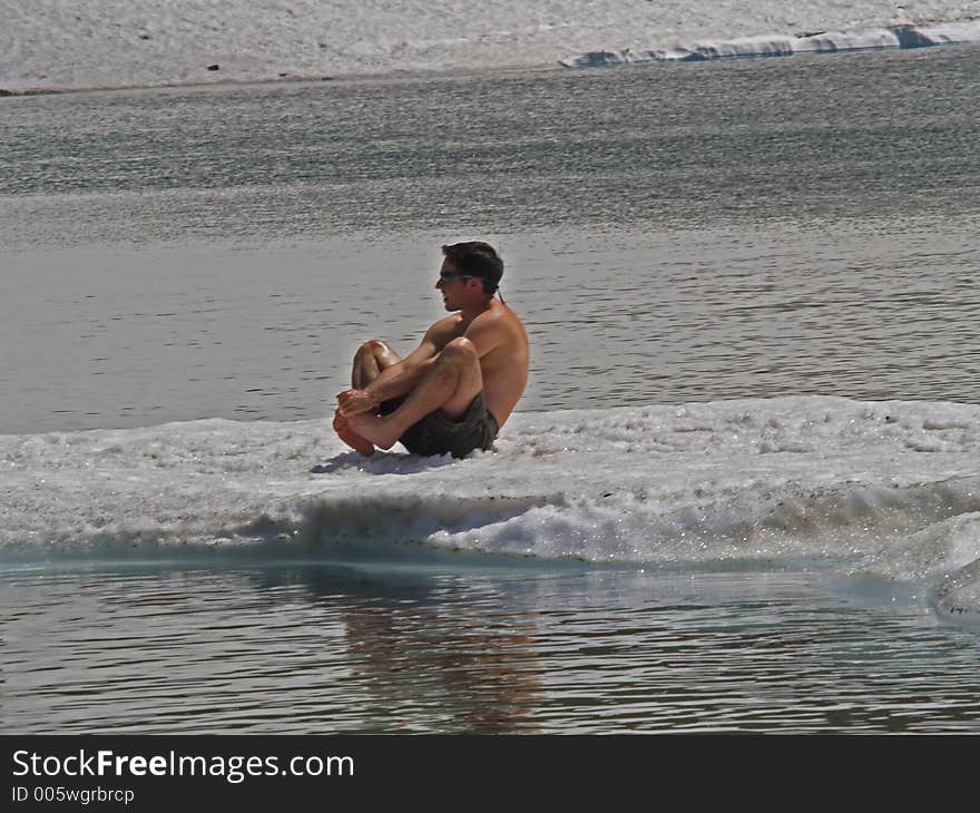 This picture of the young man sitting on an ice flow in Iceberg Lake trying to keep his feet off the ice/snow was taken in Glacier National Park.