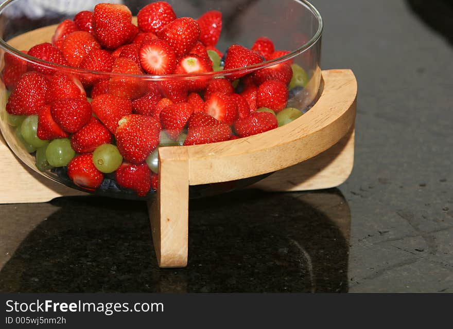 A bowl of fresh berries, strawberries, blueberries, grapes, all ready to be served as dessert. A bowl of fresh berries, strawberries, blueberries, grapes, all ready to be served as dessert.