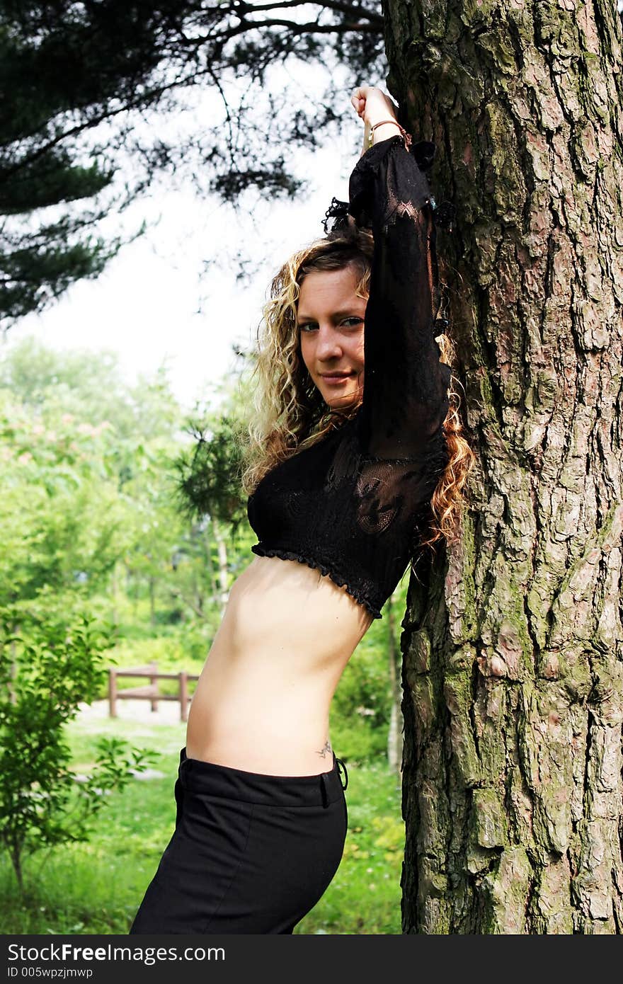 Woman In The Park Leaning On A Tree