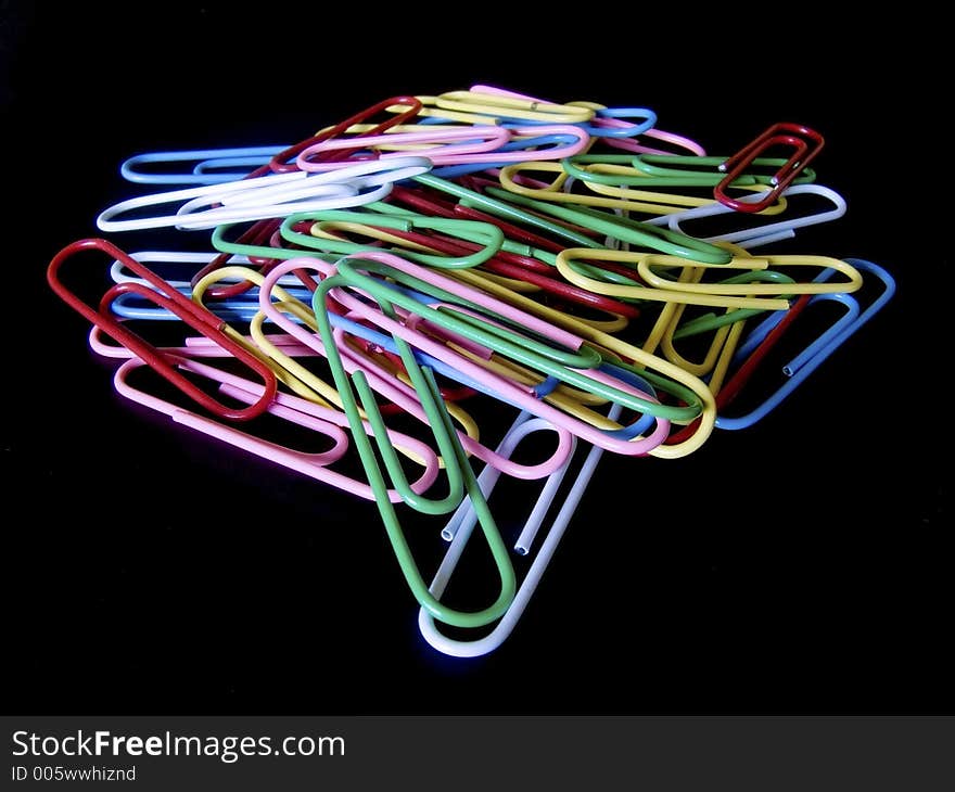 Many paperclips on black background. Many paperclips on black background