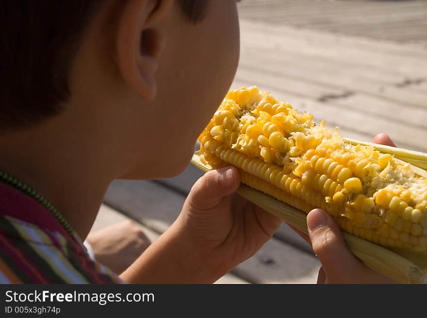 Child eating corn at the park. Child eating corn at the park