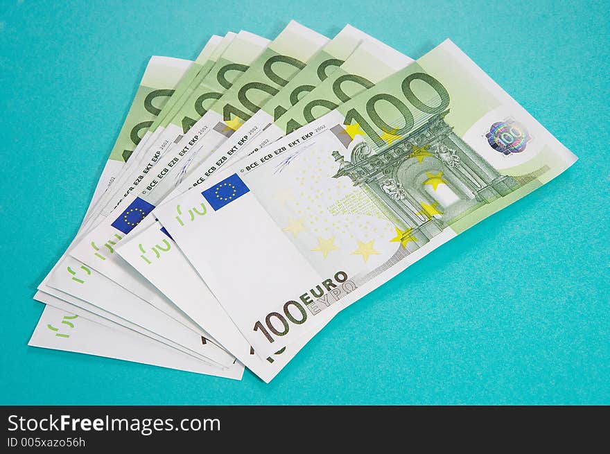 100 euro bills on turquoise background. 100 euro bills on turquoise background