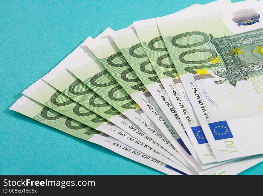 100 euro bills on turquoise background. 100 euro bills on turquoise background