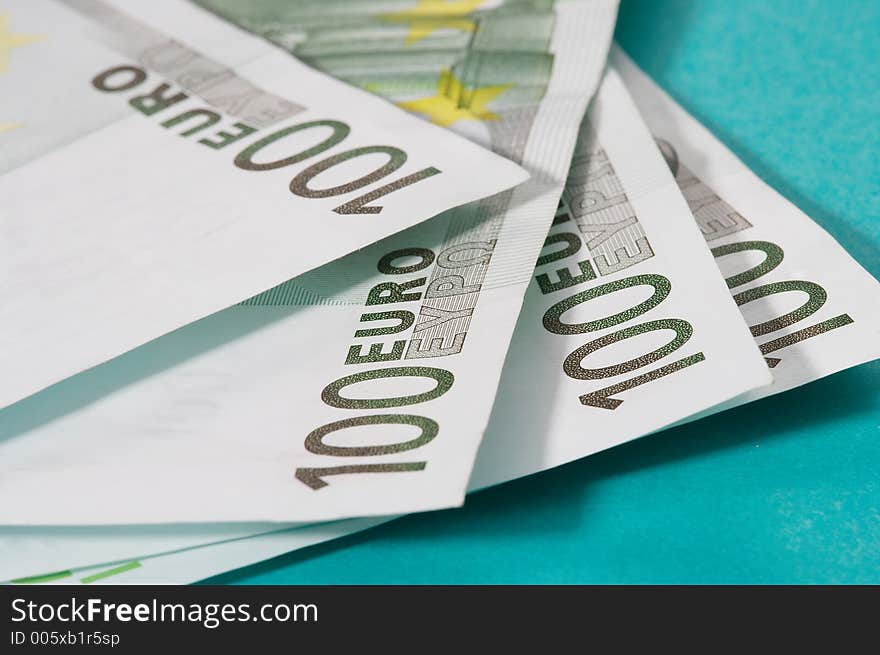 100 euro bills on turquoise background. 100 euro bills on turquoise background