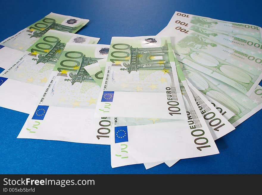 100 euro bills on blue background. 100 euro bills on blue background