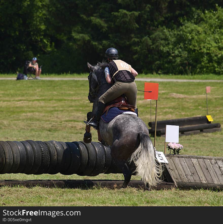 Horse and rider clearing jump in local competition. Horse and rider clearing jump in local competition