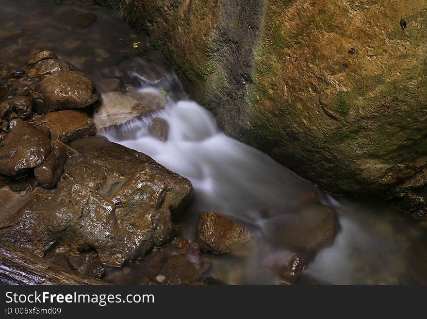 The stream runs between rocks. The stream runs between rocks