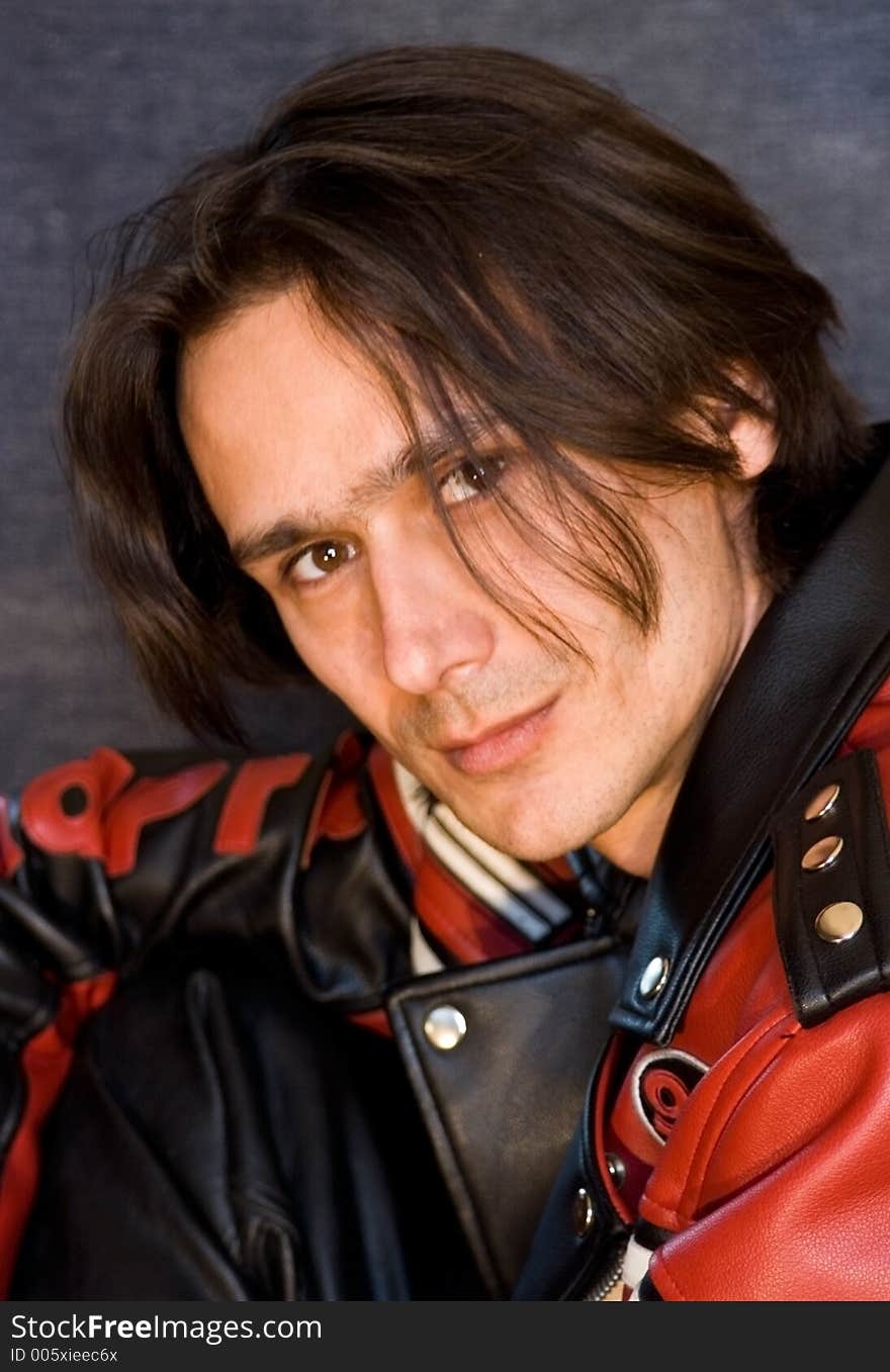 A portrait of a long-haired man in black-red jacket. A portrait of a long-haired man in black-red jacket