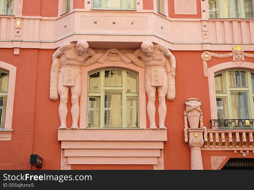 Prague building detail showing cubist-style atlantes supporting a balcony on an art nouveau facade. Prague building detail showing cubist-style atlantes supporting a balcony on an art nouveau facade