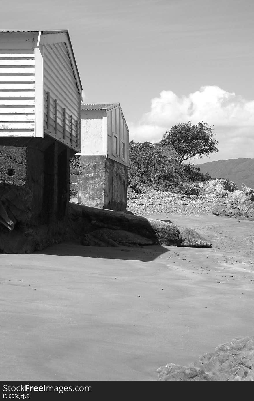 A couple of identical boat sheds on a beach