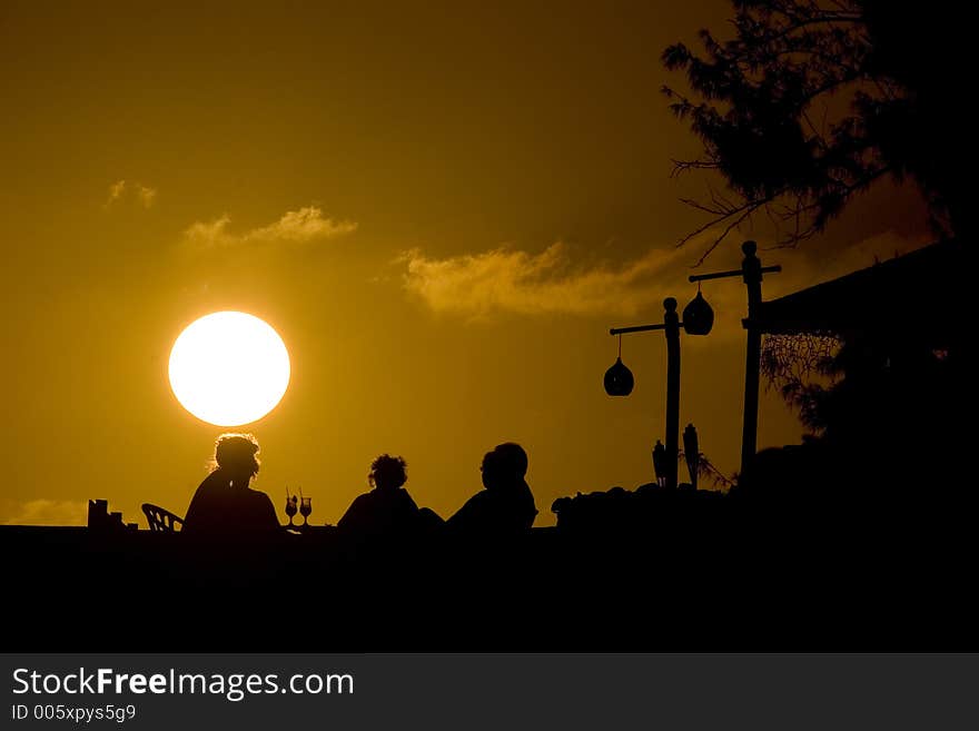 A tropical sunset and drinks with friends. A tropical sunset and drinks with friends