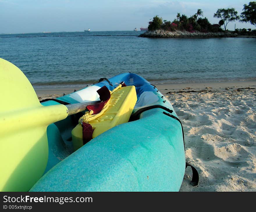 Holiday resort area with a kayak or ocean canoe, sidelit by the setting sun at 6pm, emphasis on what can be explored. Holiday resort area with a kayak or ocean canoe, sidelit by the setting sun at 6pm, emphasis on what can be explored