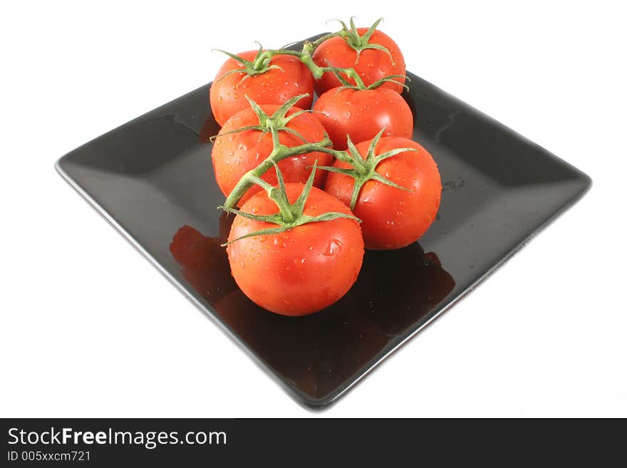 Vine Tomatoes Isolated on a black plate