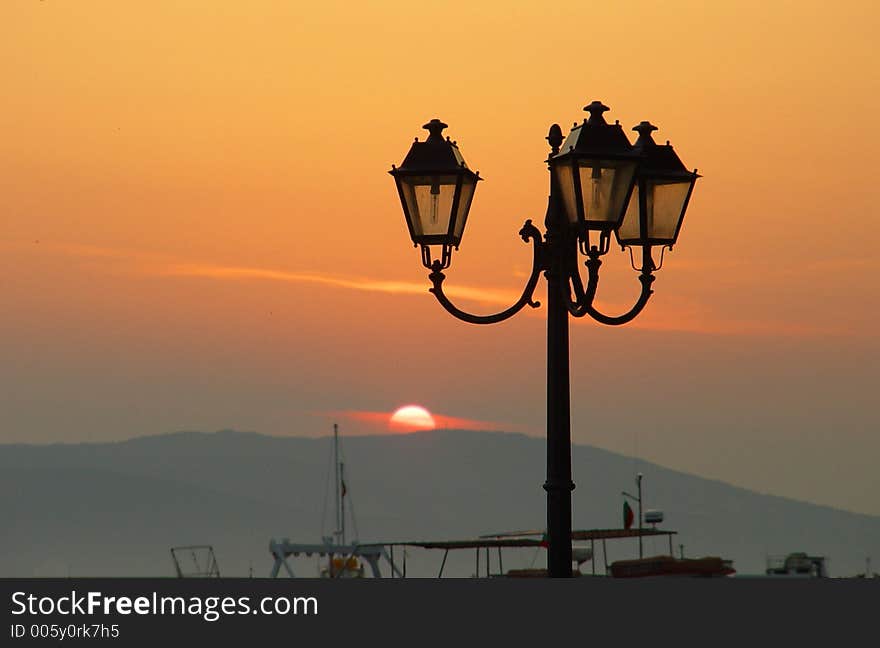 Street lamp by the sea when sun is rising