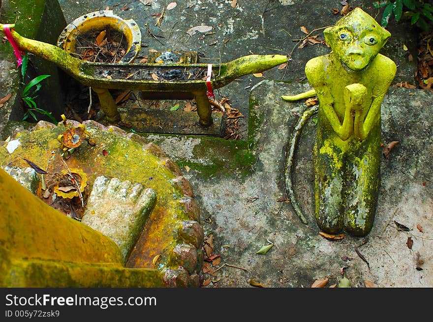 Monkey begs Buddha depiction at Wat in Surat Thani, Thailand.