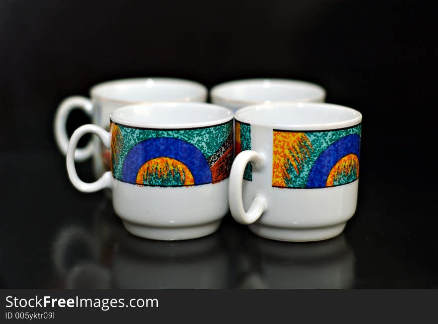 Four coffee cups on black