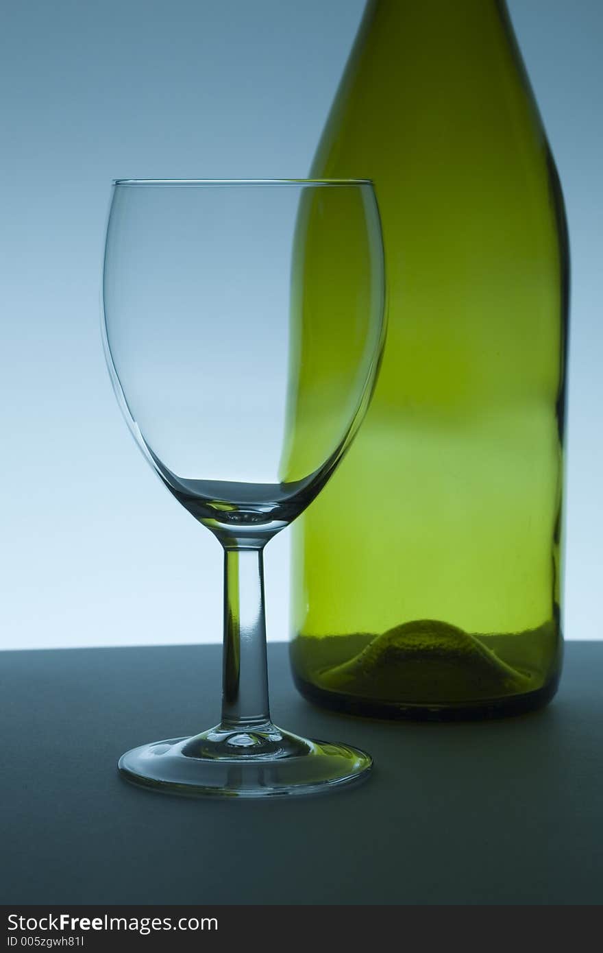 Empty green wine bottle and glass.