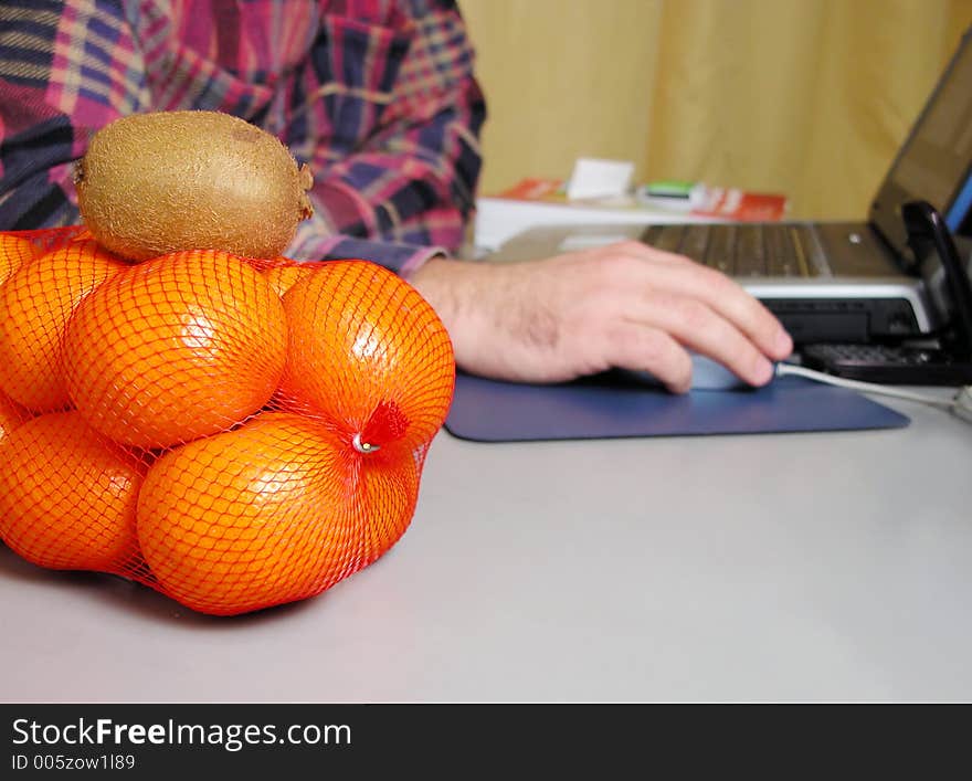 Oranges and kiwi on the office desk. The focus is on the fruits the rest of the image is blurry. Oranges and kiwi on the office desk. The focus is on the fruits the rest of the image is blurry.