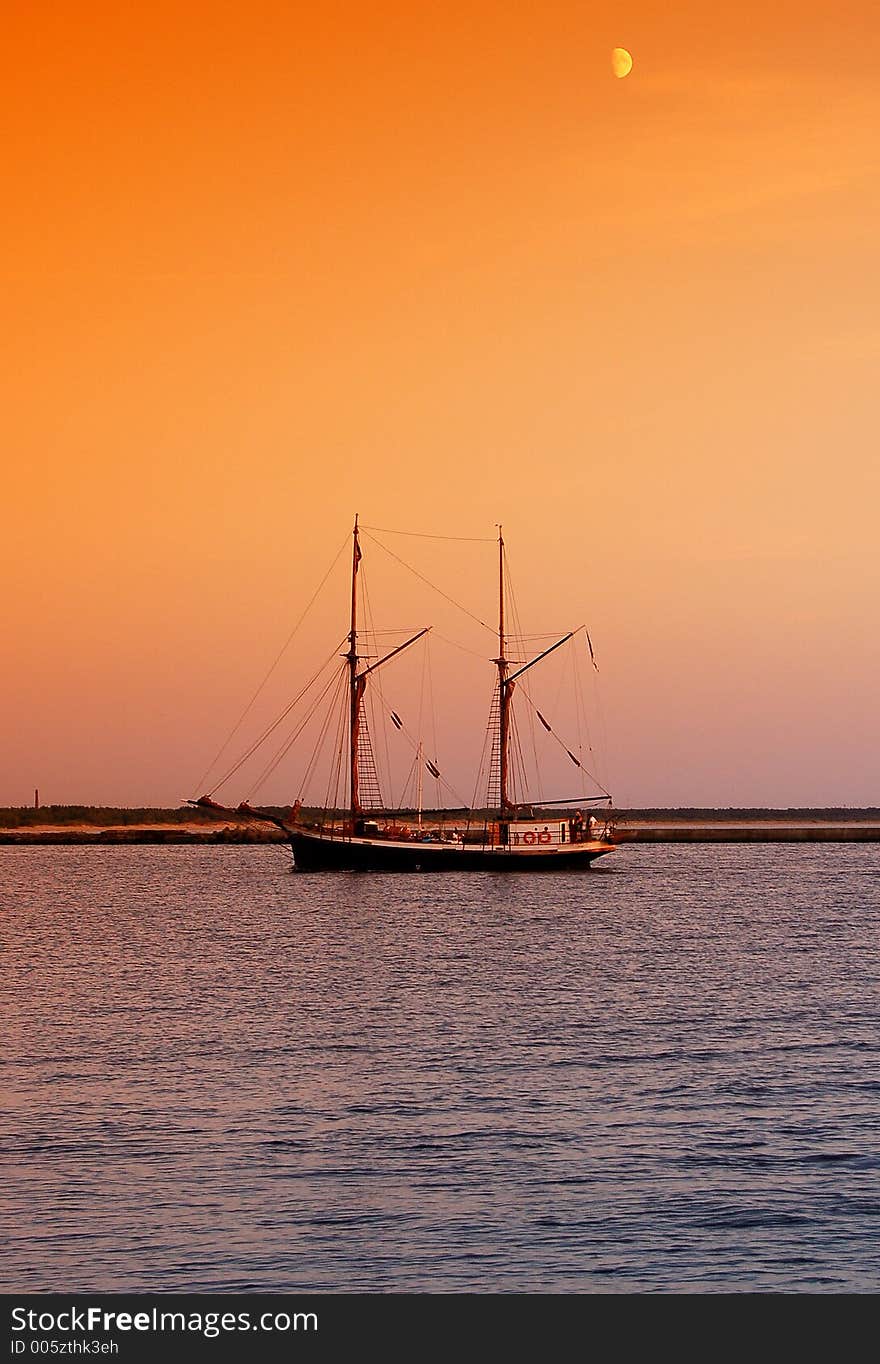 Sailboat returning to docks after sunset