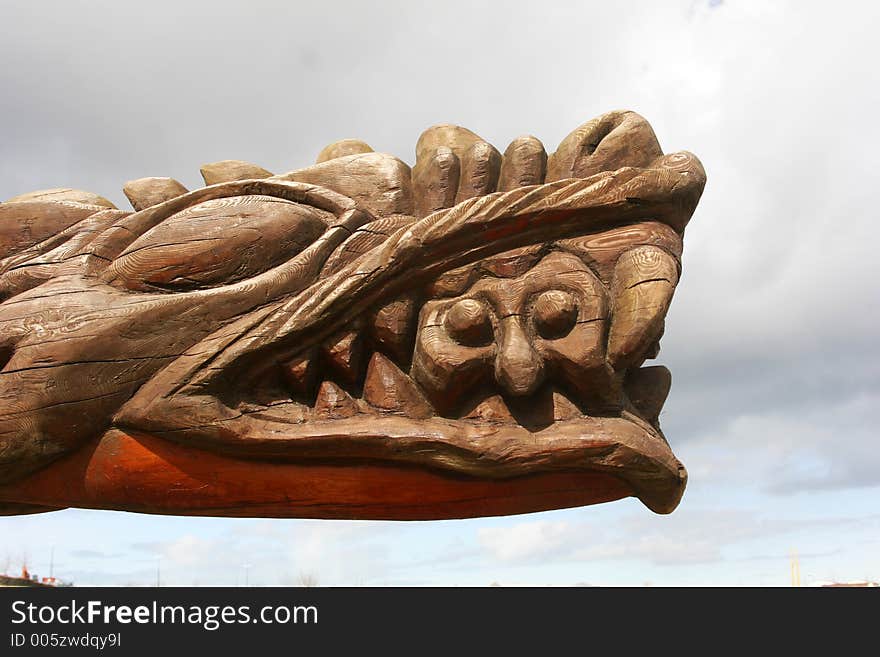 A Big carved head of a dragon with a man in its jaws