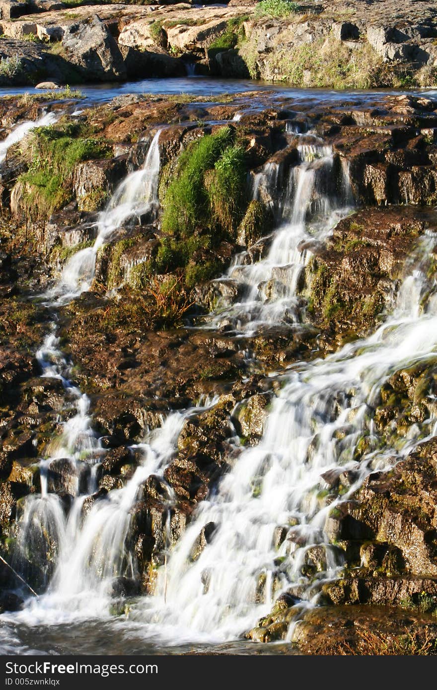 Photograph of small river, flowing, waterfalls, lush green vegetation and genuine tranquil athmosphere. Photograph of small river, flowing, waterfalls, lush green vegetation and genuine tranquil athmosphere