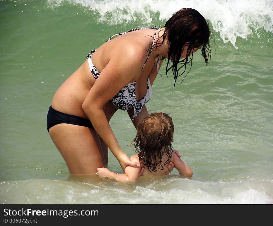 Mother holding child in the ocean waves. Mother holding child in the ocean waves