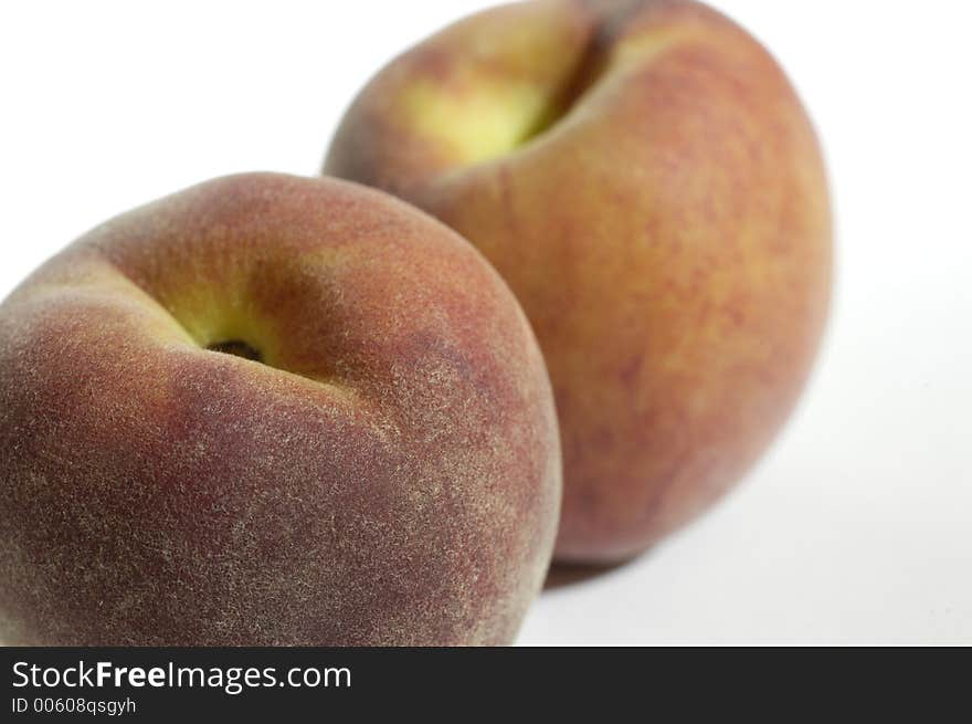 Two peaches in close-up against a white background