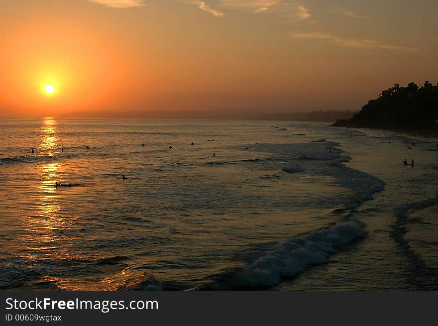 Beautiful sunset on the ocean, people swimming, enjoying warm water. Beautiful sunset on the ocean, people swimming, enjoying warm water