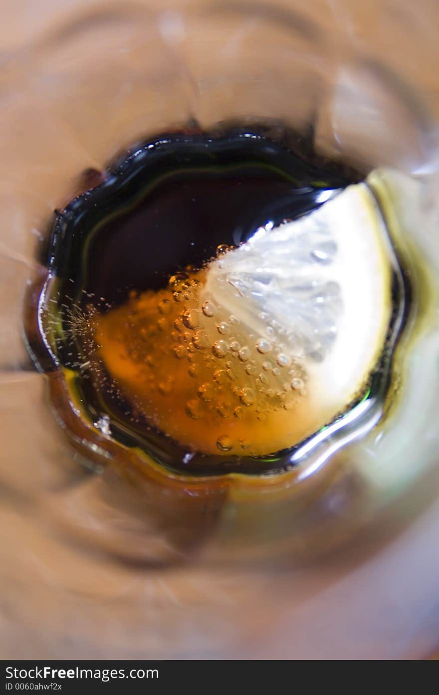 Close up from above of a glass of coke and lemon