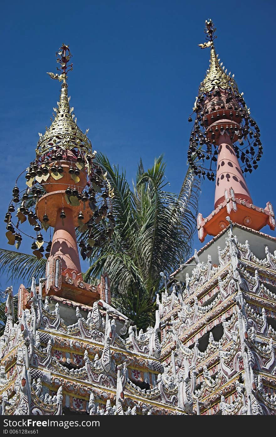 Elaborate roof on an Indian in Malaysia; blue sky and palm trees in background. Elaborate roof on an Indian in Malaysia; blue sky and palm trees in background