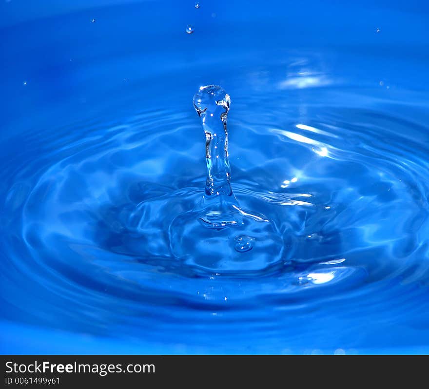 Water drop falling into a bowl filled with water and bouncing  up again. Water drop falling into a bowl filled with water and bouncing  up again