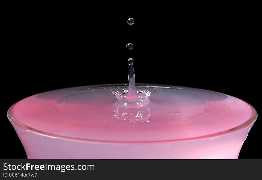 Pink water drops in a glass