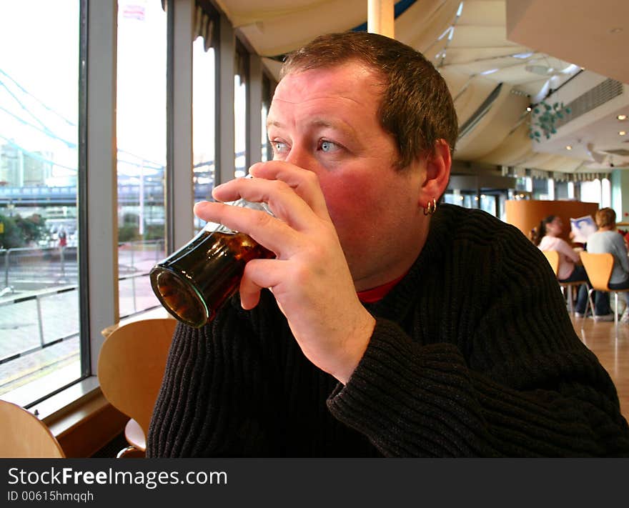 Man drinking cola in cafe