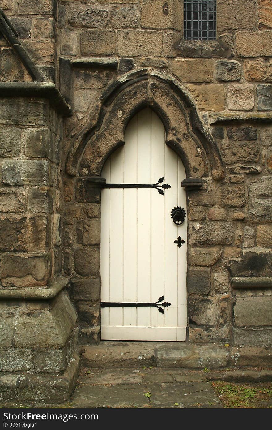 White door at the side of a church with beautiful stone surround