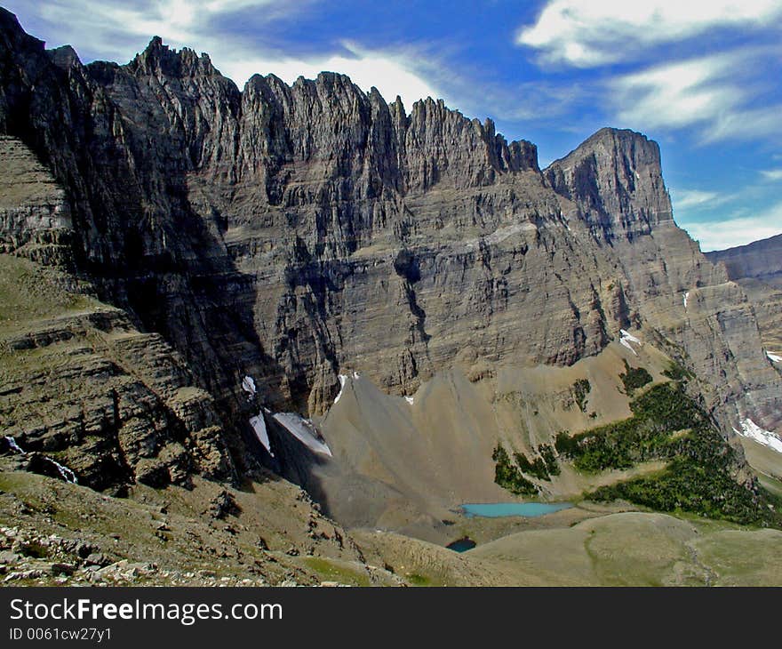 This picture was taken from Piegan Pass and shows the backside of the Garden Wall and a small snow melt pond in Glacier National Park. This picture was taken from Piegan Pass and shows the backside of the Garden Wall and a small snow melt pond in Glacier National Park.