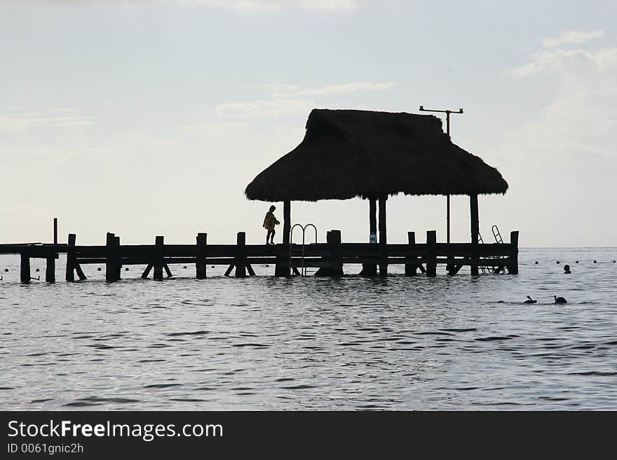 Silhouette of a persone walking on a pier. Silhouette of a persone walking on a pier