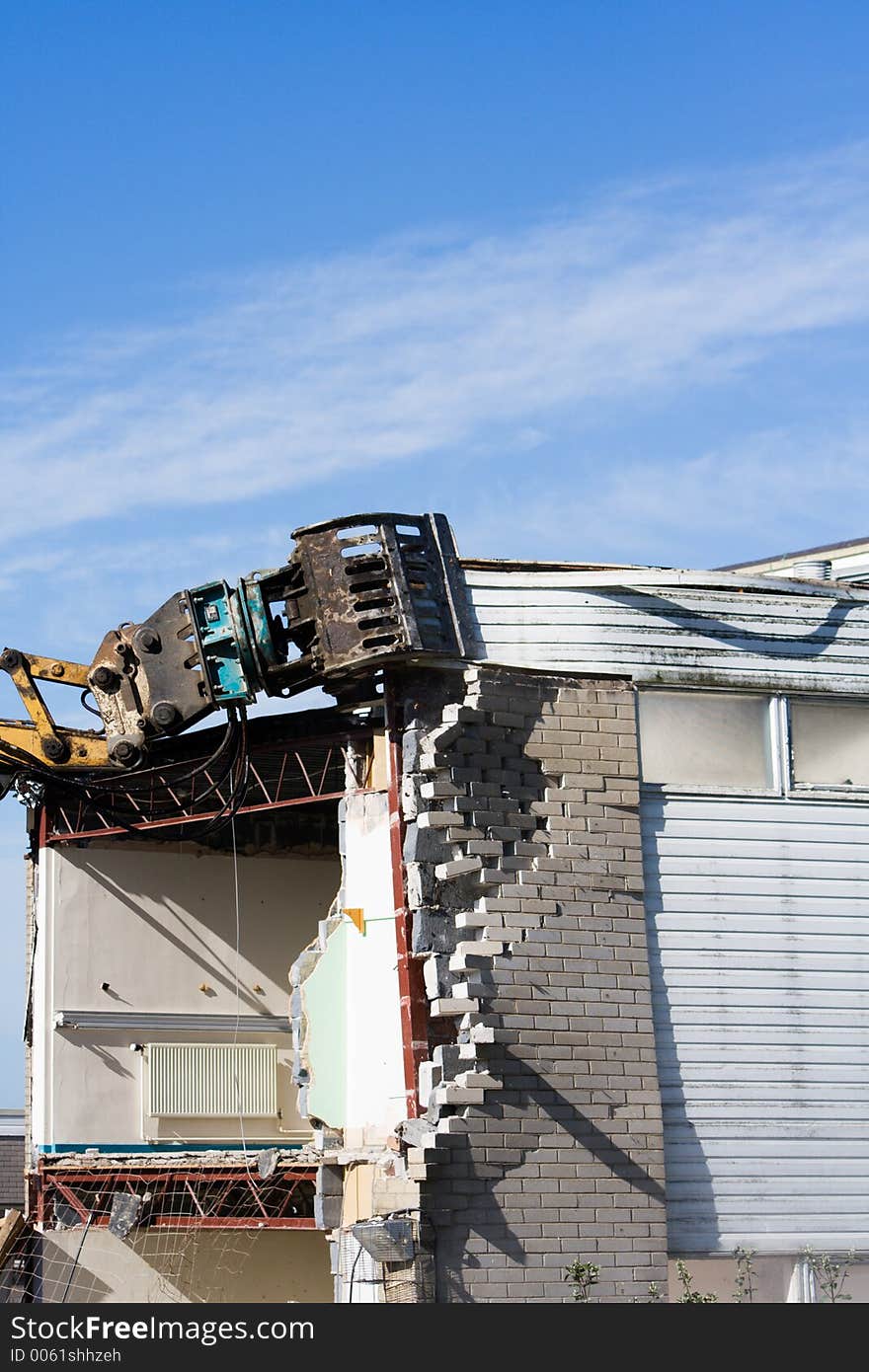 Mechanical demolisher tears down a building. Mechanical demolisher tears down a building