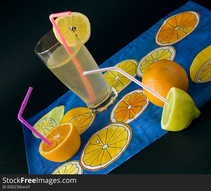 Fresh fruits, lemon juice at napkien with citrus motives. Fresh fruits, lemon juice at napkien with citrus motives