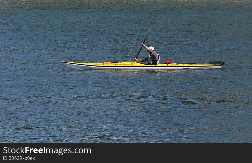 Young man kyaking across lake. Young man kyaking across lake