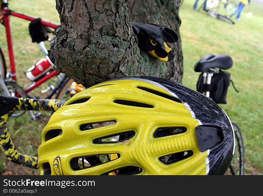 A bike rider leaves his equipment along a tree when he takes a break. A bike rider leaves his equipment along a tree when he takes a break