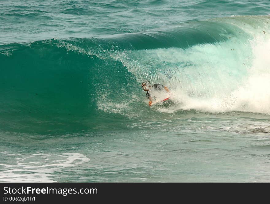 Bodyboarder glides through a green tube. Bodyboarder glides through a green tube.