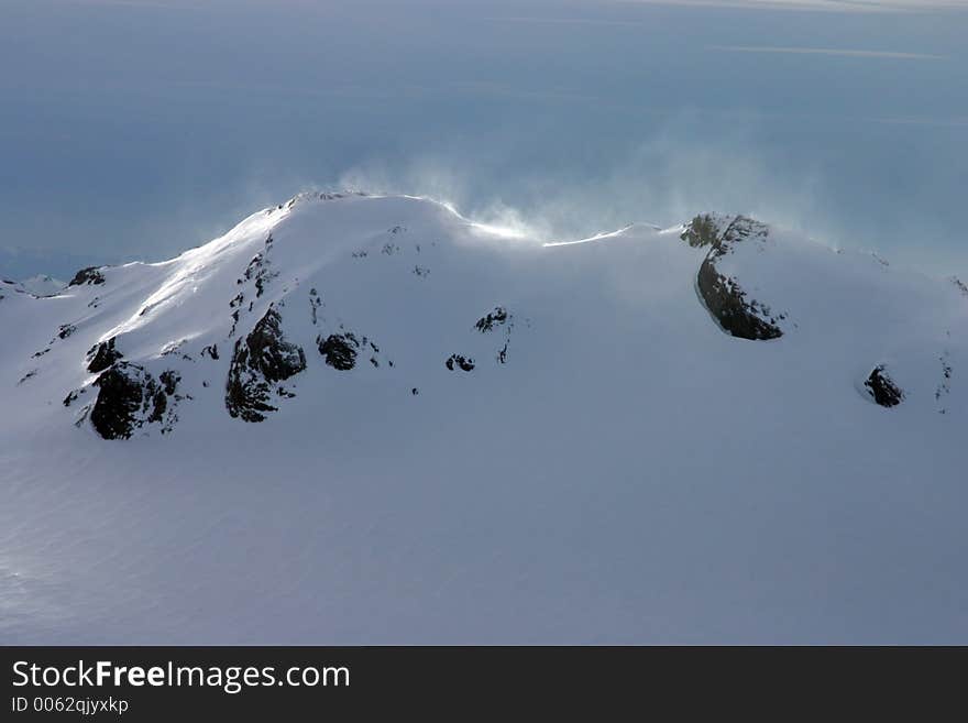 Snow moved by the wind on a back-lit summit (taken from a plane, Switzerland). Snow moved by the wind on a back-lit summit (taken from a plane, Switzerland)