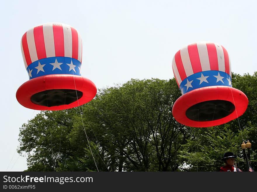 Baloon float of hats in a parade.