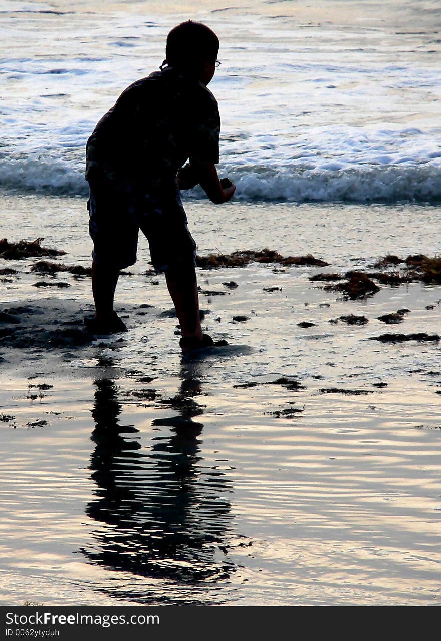 Silhouette of young boy playing at the seashore. Silhouette of young boy playing at the seashore