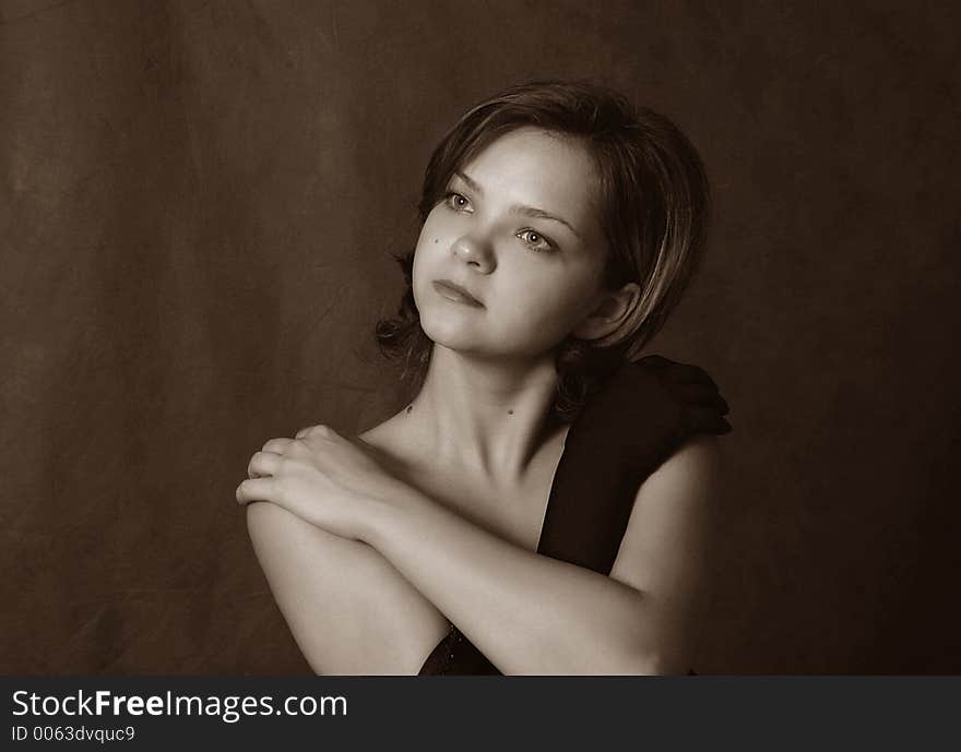 Portrait of the beautiful girl on a dark background. b/w+sepia